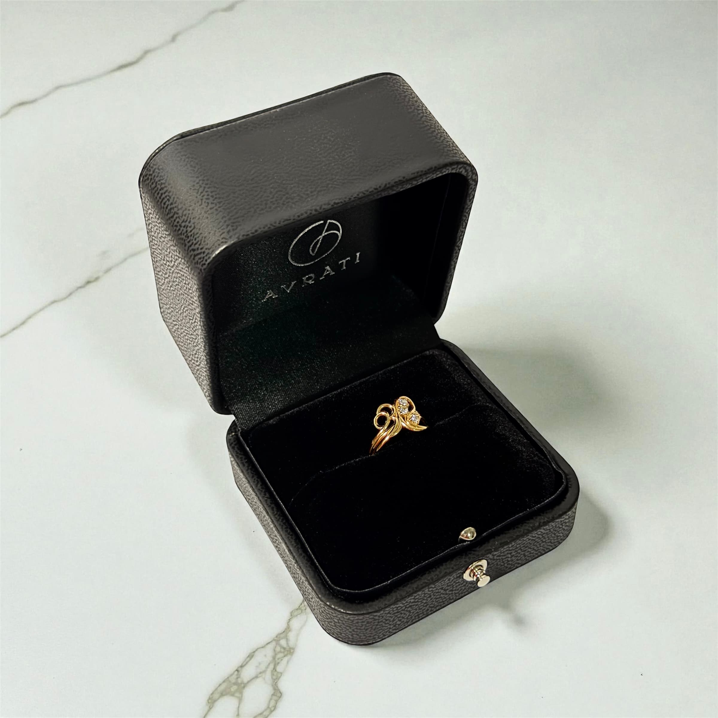Anillo de oro en caja Avrati sobre mármol